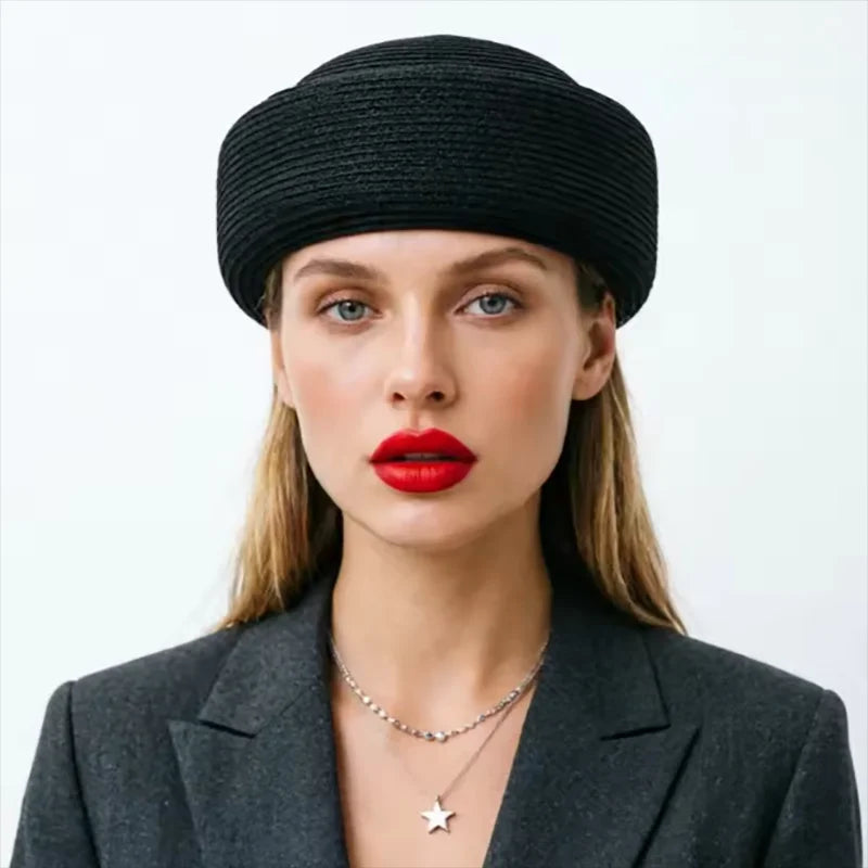 A woman wearing a black knitted beanie and a gray blazer looking directly at the camera.