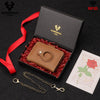 A brown leather smart wallet with a metal ring and chain is displayed in a black box with red ribbon and a note.