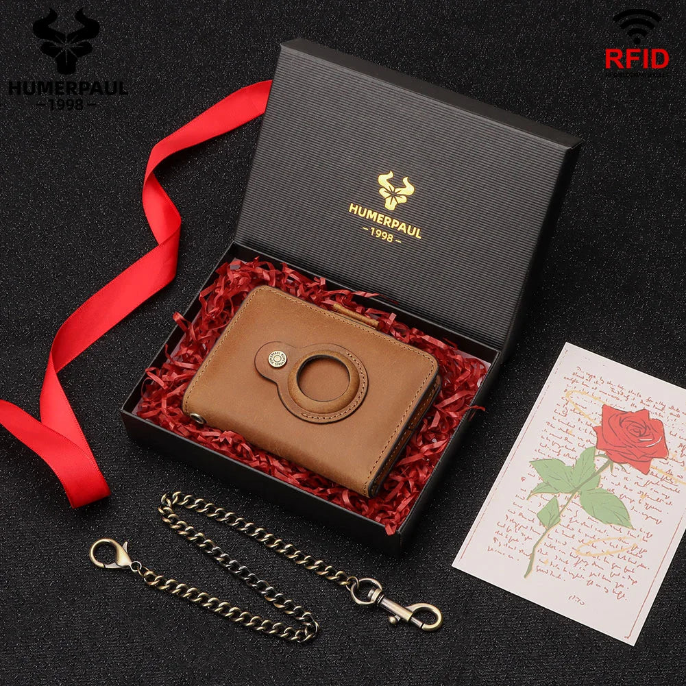 A brown leather smart wallet with a metal ring and chain is displayed in a black box with red ribbon and a note.