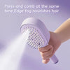 A hand is using a purple ionic steam hair brush to fog nourish hair.