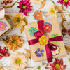 A collection of glitter flower round stickers in various colors scattered on a wooden surface.
