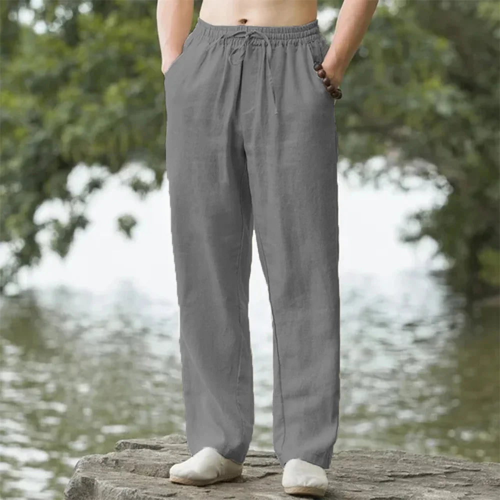 A person is wearing gray men's cotton linen casual jogger pants outdoors.