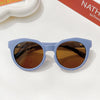 Light blue sunglasses with brown lenses resting on a white surface.