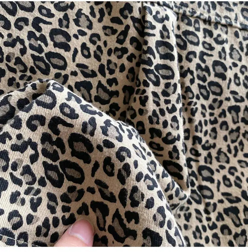 Close-up of a beige leopard print denim fabric showing texture and stitching.