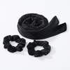 Black heatless curling rod headband rolled up and two separate bands shown on a white background