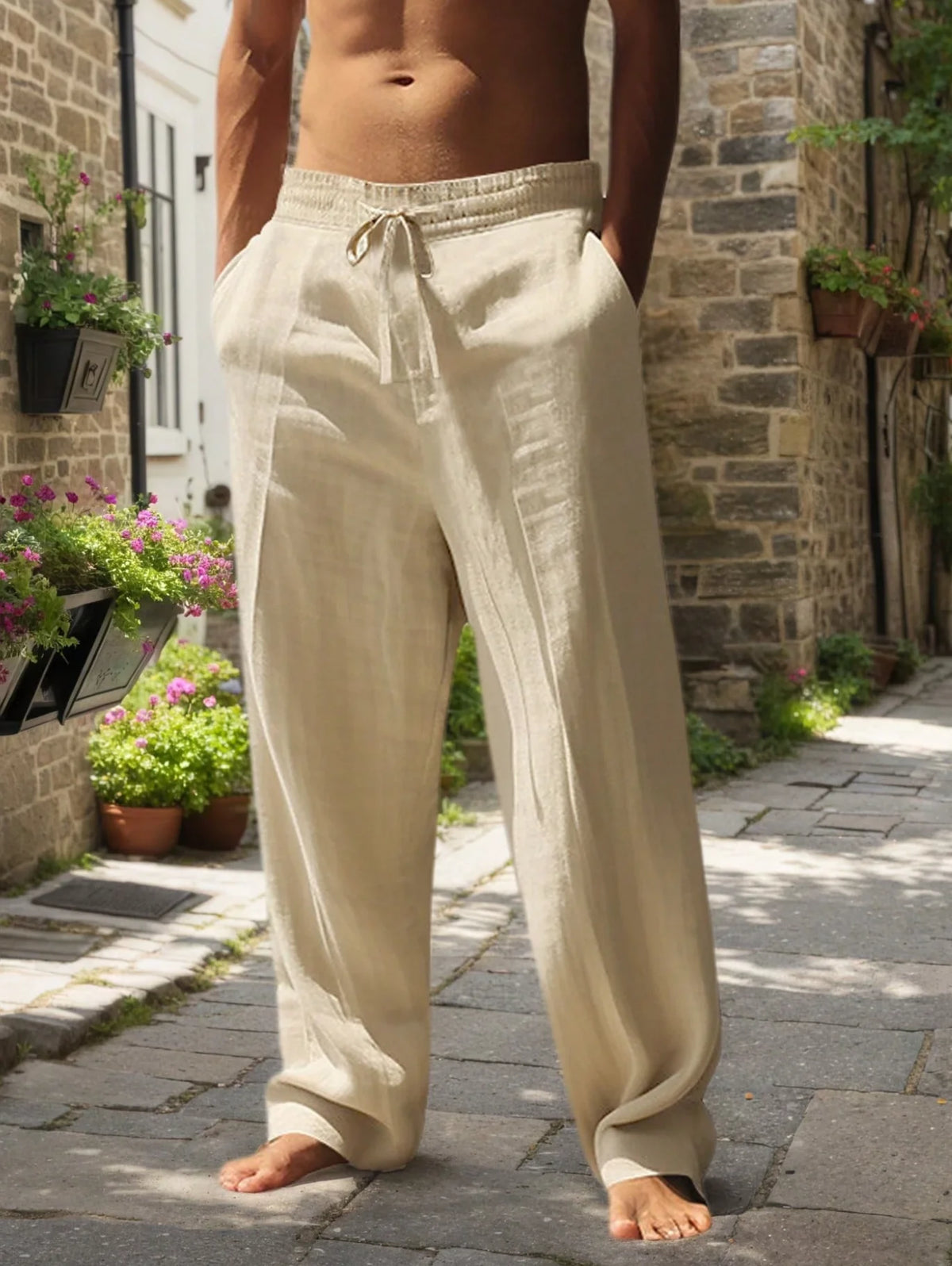 Hombre con pantalones casuales de mezcla de algodón color beige, de corte holgado, de pie sobre un camino de piedras.