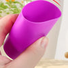 A hand holds a vibrant purple cup, demonstrating its use in a stacking game.