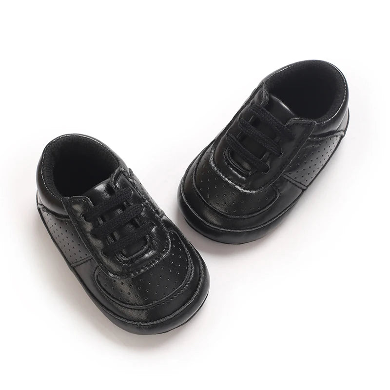 A pair of black soft sole baby pre-walker sneakers for infants shown from above.
