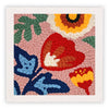 Firkantet broderi med farverige blomster i orange, rød, grøn og blå på beige stof.