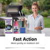 Une femme tient une bouteille de spray nettoyant et dégraissant et des outils métalliques devant un gril de BBQ.