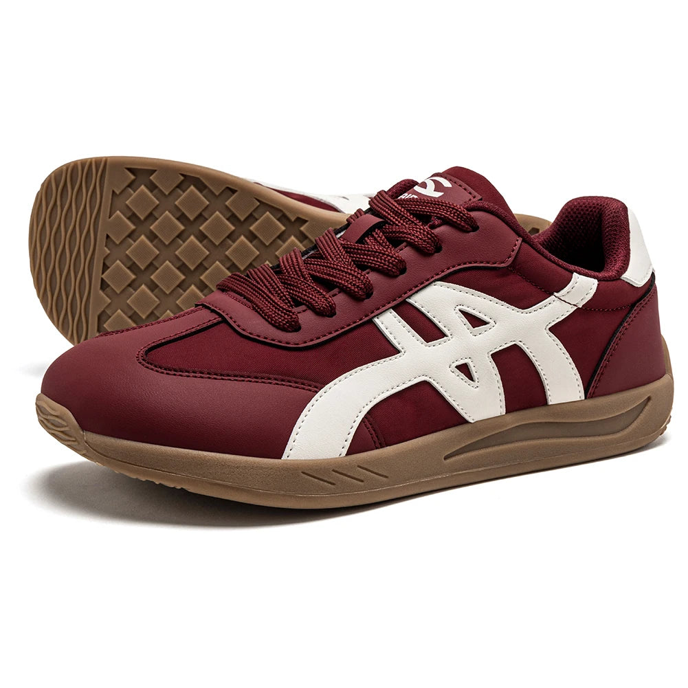 Ein bordeauxroter und weißer Sneaker mit brauner Sohle von der Seite gezeigt.