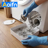 A hand in a blue glove is draining water from a washing machine filter drain tray into a white container.