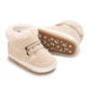 A pair of beige baby winter snow boots with fluffy shearling lining and a brown sole.