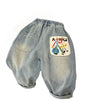 Light wash denim jeans with an elastic waist and a patch featuring cartoon people.