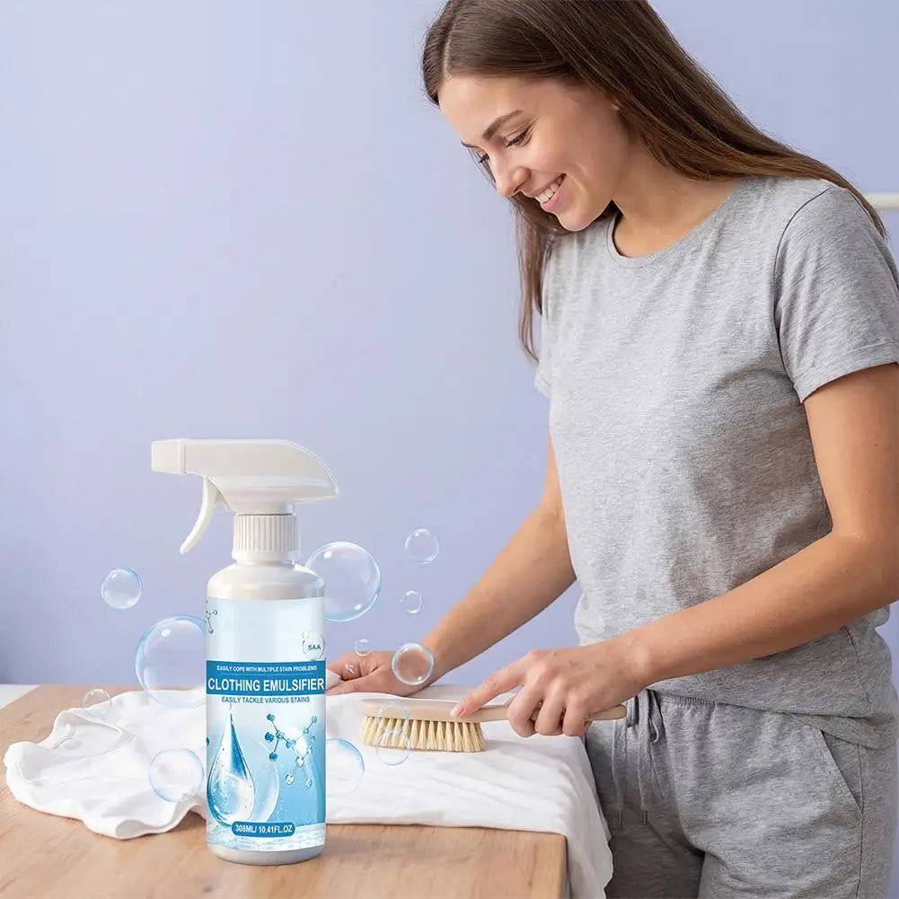 A woman is applying a bottle of clothing stain remover spray onto a white cloth.