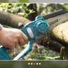A person is using a blue cordless 6 inch chainsaw and pruning shears combo kit to cut a tree branch.