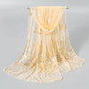 A sheer gold shimmer chiffon scarf and head wrap displayed on a hanger.