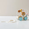 A wooden Montessori stacking train toy featuring animal blocks like a lion and moon, with a string for pulling.