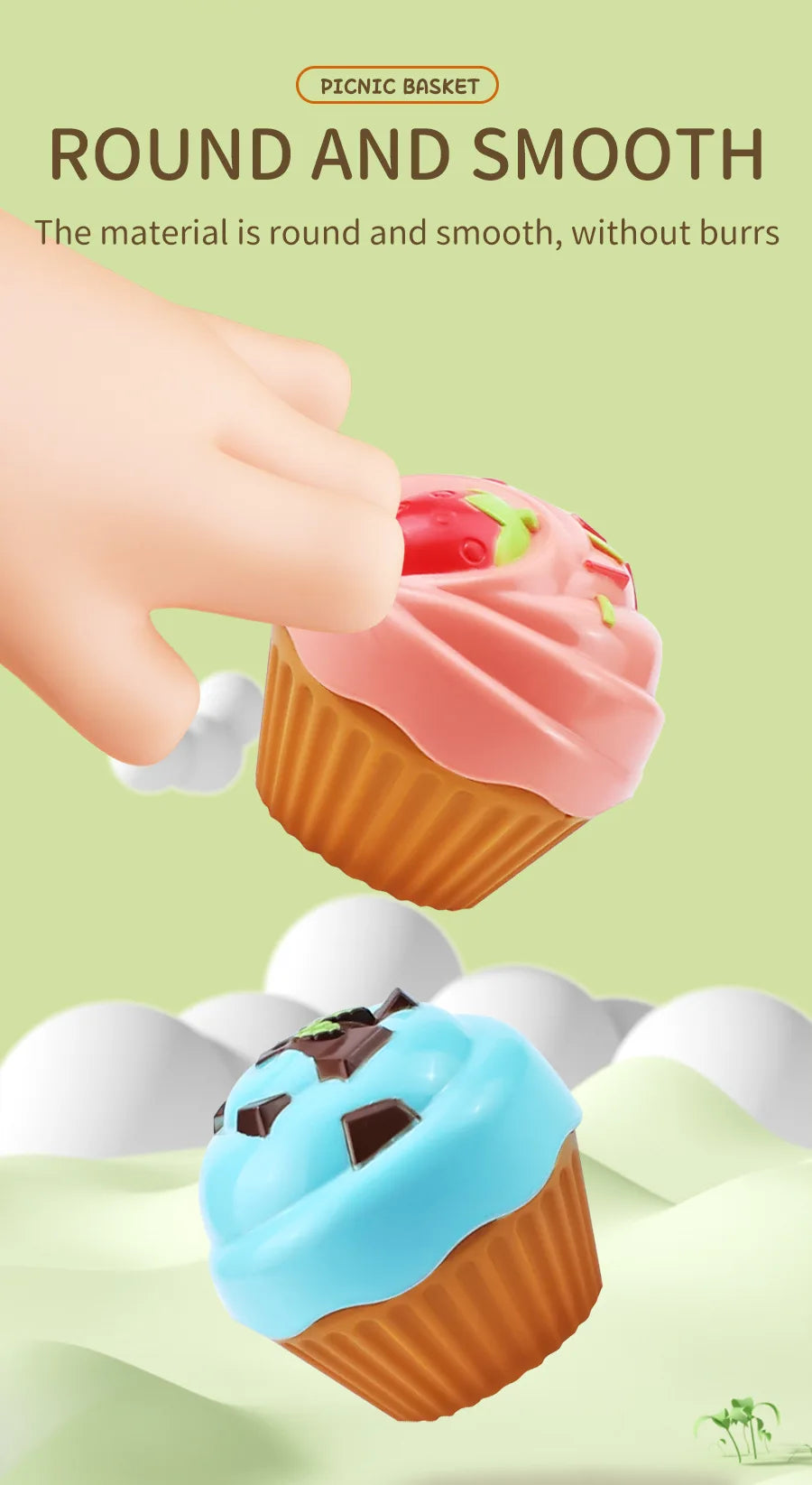 A hand is holding a pink frosted cupcake in an orange paper liner, demonstrating the smooth material of a picnic basket produ
