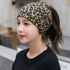 Kvinne modellerer et leopardmønstret pannebånd eller lue-skjerf med mørkt hår og svart genser.