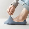 A person's foot is shown wearing a blue silicone grip no-show sock.