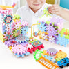 A child is assembling a colorful motorized gear building set featuring gears, tracks, and a blue toy car.