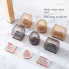 A collection of silicone furniture leg pads in various shapes and translucent colors resting on a white marble surface.