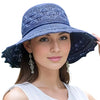 A woman wearing a navy blue foldable sun visor hat with lace trim.
