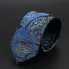 Corbata de jacquard estampada en azul oscuro y dorado, doblada sobre un fondo negro.