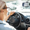 En kvinne kjører bil med en telefon montert på frontruten med et 360-graders roterbart feste.