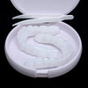 A white cosmetic denture teeth kit with a plastic tray and a small spatula is displayed in an open container.