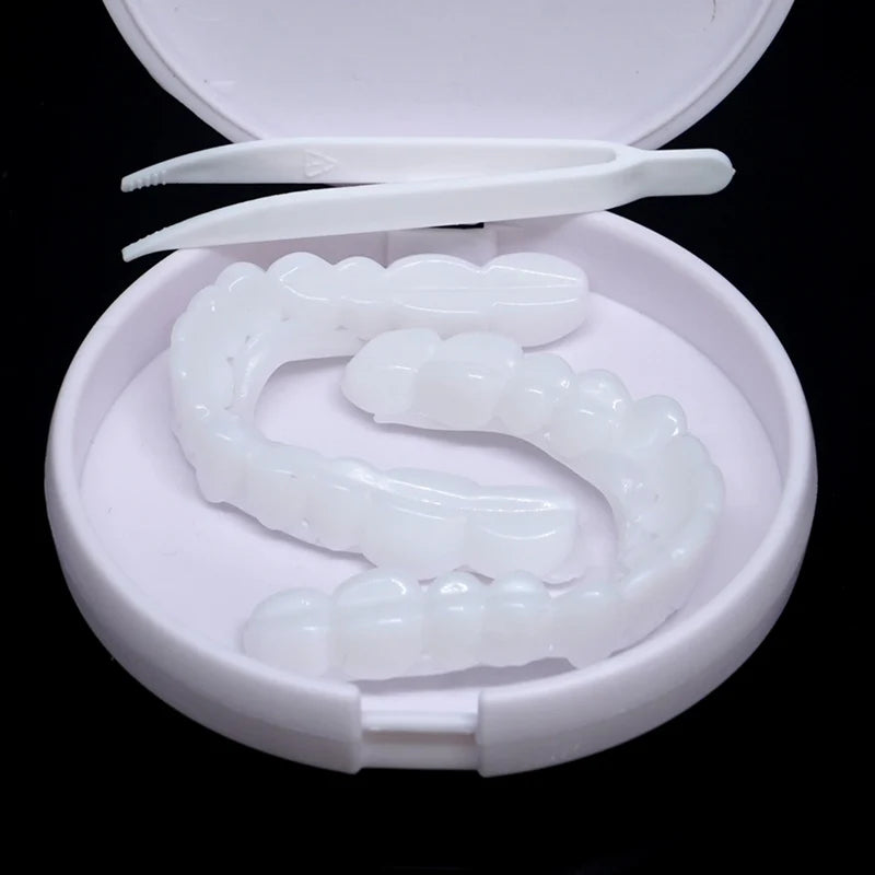 A white cosmetic denture teeth kit with a plastic tray and a small spatula is displayed in an open container.