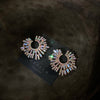 Pendientes de flor de cristal sobredimensionados sobre terciopelo oscuro.