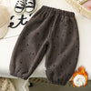 Dark gray fleece pants with small heart patterns laid out on a white surface.
