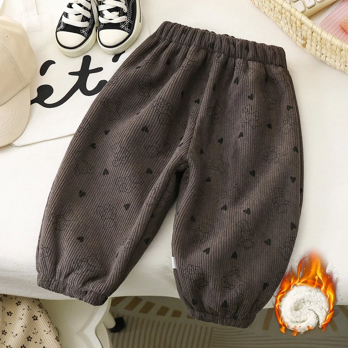 Dark gray fleece pants with small heart patterns laid out on a white surface.