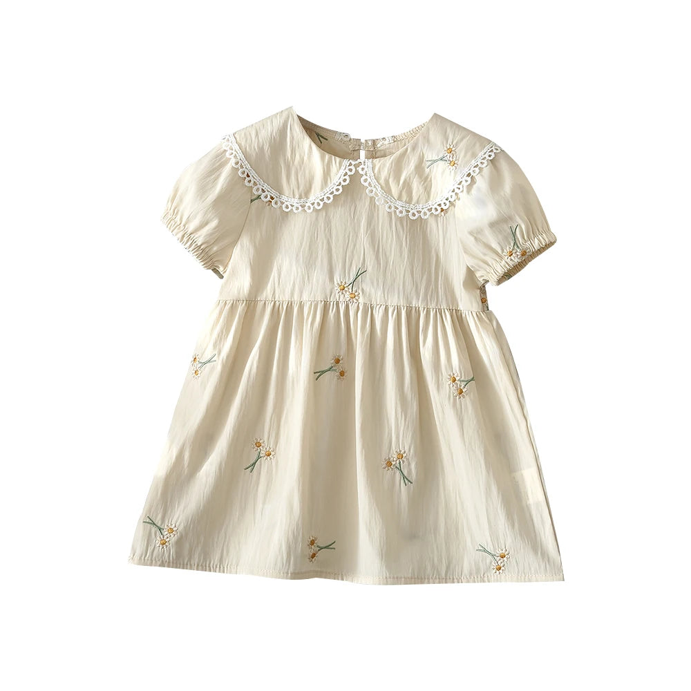 A light beige girls summer dress with white floral embroidery and delicate lace trim.