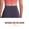 A model wears a pink sports bra and dark gray athletic bottoms, demonstrating fit and comfort.