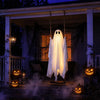 Hvid spøgelsesdekoration hænger fra et reb foran et hus en Halloween-nat.
