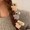 قصة شعر امرأة بضفيرة مزينة بمشابك شعر صغيرة ناعمة على شكل كوالا.