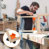 A man is using adjustable right-angle clamps on a wooden workbench for woodworking projects.