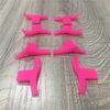 A set of pink silicone winged eyeliner stencils arranged on a light wooden surface.