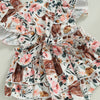 A floral print baby romper featuring brown cow print fabric with ruffled details.