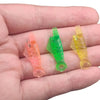A hand holds five colored auto needle threaders, including pink, green, and yellow plastic tools.