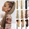 A woman shows off long, straight hair extensions in shades of blonde and brown, styled in a ponytail.