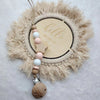 A personalized wooden and silicone pacifier chain with teether beads featuring a circular wooden tag that reads hello world s