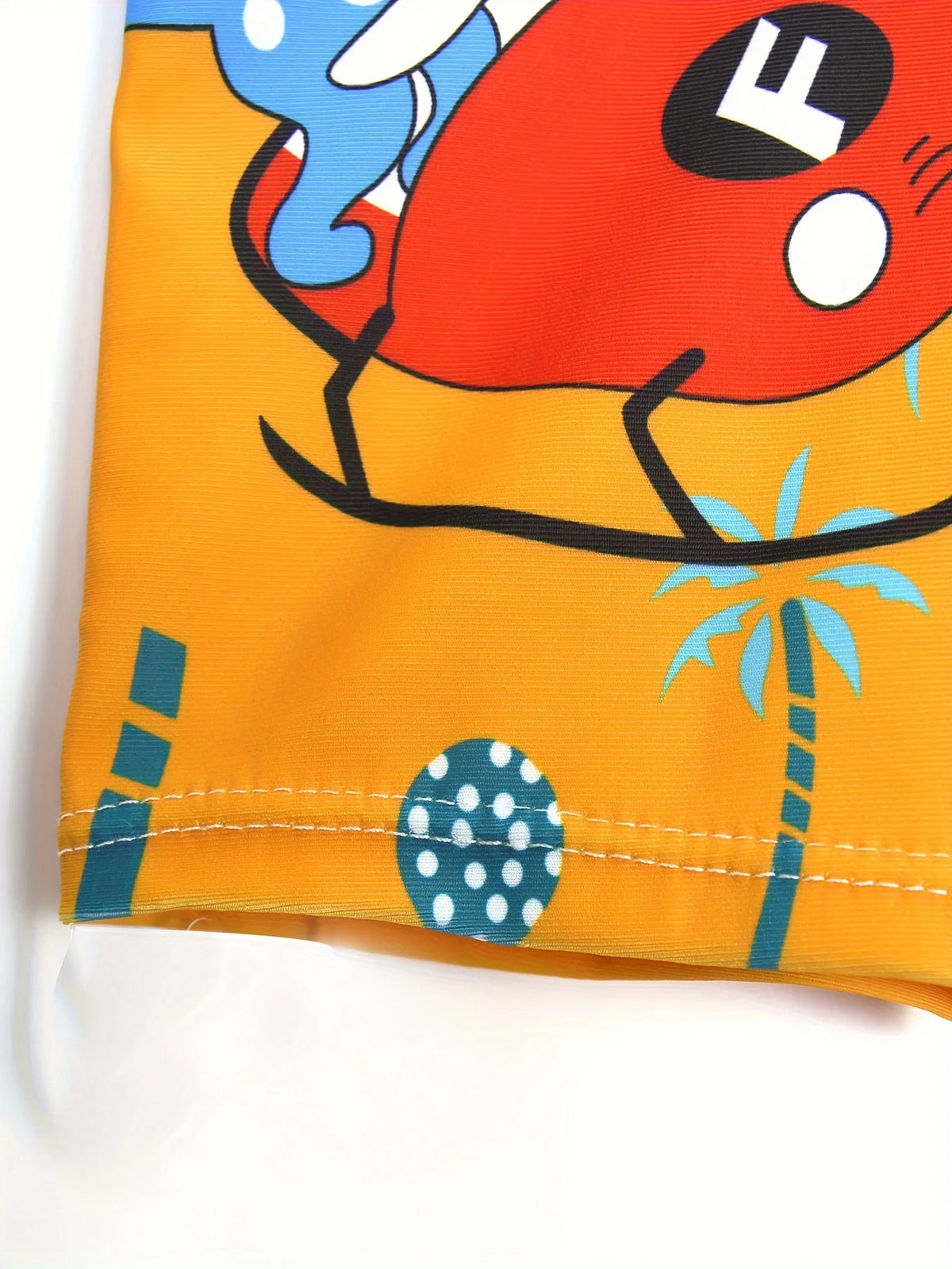 Orange swim trunks featuring a cartoon dinosaur design with blue and black accents.