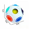 A white, multi-colored fidget cube ball with a yellow center and various colored segments.