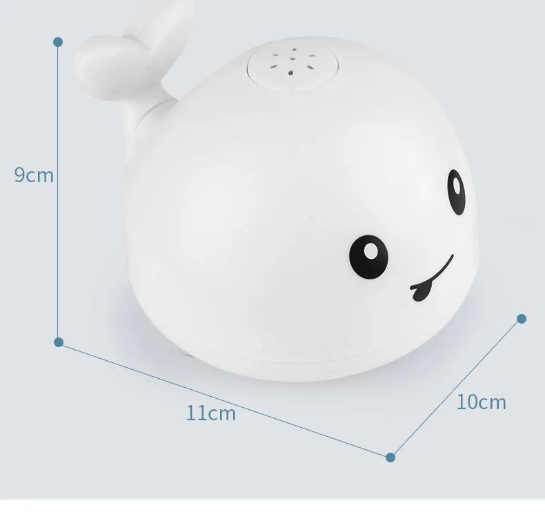 A white musical whale bath toy with a light-up water spray is shown from above.
