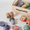 A wooden pretend play food cutting set with various vegetable shapes and a wooden box.