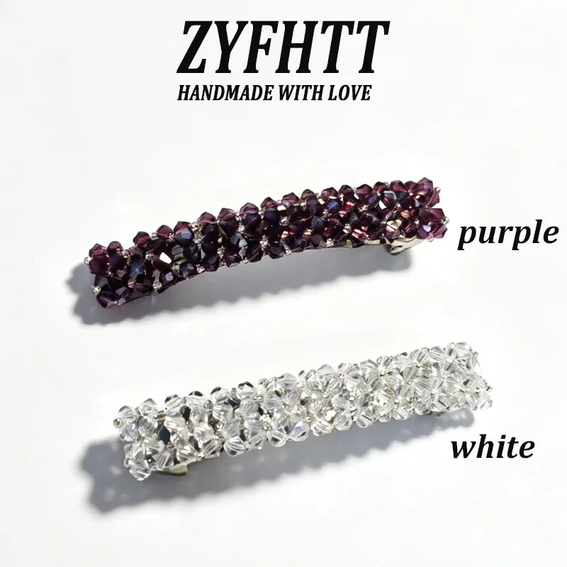 Dos pinzas para el cabello artesanales con cristales de strass, una morada y una blanca.